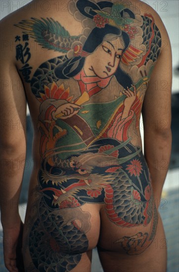 JAPAN, People, Yakuza, Cropped shot of heavily tattooed back of gangster or Yakuza gang member in public bath house.  Design depicts a musician and dragon.