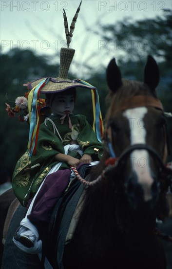 JAPAN, Honshu, Kyoto, Gion Festival.  A young boy dressed as a courtier of the Heian period prepares to ride through the streets of Kyoto.