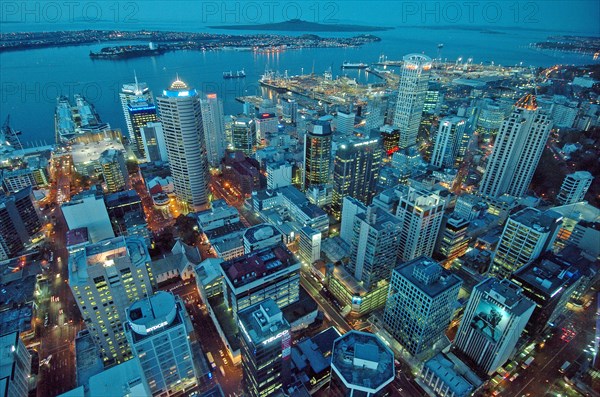 NEW ZEALAND, NORTH ISLAND , AUCKLAND , GENERAL VIEW OF AUCKLAND CITY CENTRE AT DUSK FROM THE AUCKLAND SKY TOWER WITH VIEWS ACROSS AUCKLAND HARBOUR TO THE DISTRICT OF DEVENPORT AND RANGITOTO ISLAND BEHIND.