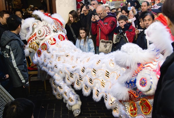 ENGLAND, London, Chinatown, Lion Dance troupe and embroidered banners in Gerrard Street amongst the crowd during Chinese New Year celebrations in 2006 for the coming Year of The Dog