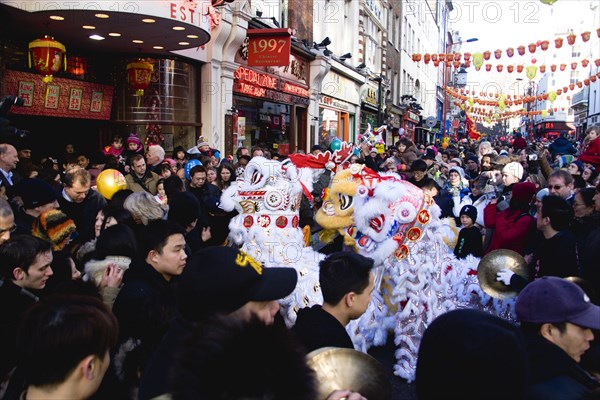 ENGLAND, London, Chinatown, Lion Dance troupe performing in Wardour Street with onlooking crowd during Chinese New Year celebrations in 2006 for the coming Year of The Dog