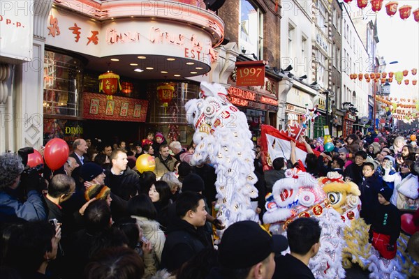 ENGLAND, London, Chinatown, Lion Dance troupe and musicians performing in Wardour Street amongst the crowd outside restaurants during Chinese New Year celebrations in 2006 for the coming Year of The Dog