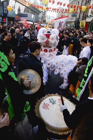 ENGLAND, London, Chinatown, Lion Dance troupe performing in Wardour Street amongst the crowd outside restaurants during Chinese New Year celebrations in 2006 for the coming Year of The Dog