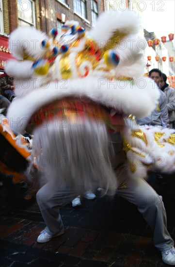 ENGLAND, London, Chinatown, Lion Dance troupe performing in Gerrard Street with onlooking crowd during Chinese New Year celebrations in 2006 for the coming Year of The Dog