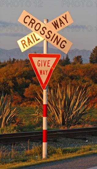 NEW ZEALAND, SOUTH ISLAND, WEST COAST, "HOKITIKA, RAILWAY LEVEL CROSSING ROAD SIGN ON THE WESTERN COASTAL ROAD ROUTE 6 OUTSIDE HOKITIKA ON THE SOUTH ISLAND. THE SIGN WARNS OF FRIEGHT TRAINS RUNNING FROM GREYMOUTH TO HOKITIKA."