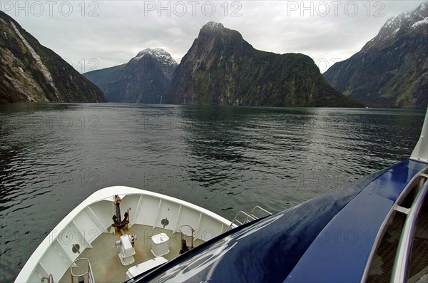 NEW ZEALAND, SOUTH ISLAND, "MILFORD SOUND,", "SOUTHLAND, REAL JOURNEYS CRUISE BOAT THE MILFORD MARINER TRAVELS ALONG MILFORD SOUND IN NEW ZEALANDS FJORDLAND AREA."