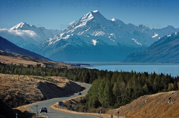 NEW ZEALAND, SOUTH ISLAND, WEST COAST, "MOUNT COOK NATIONAL PARK, VIEW OF NEW ZEALANDS HIGHEST MOUNTAIN MOUNT COOK (CENTRE) AND MOUNT HICKS (LEFT) WITH SUN ON THEIR WEST FACES WITH LAKE PUKAKI BELOW TAKEN FROM ROUTE 80 MOUNT COOK ROAD."