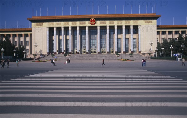 CHINA, Beijing, "Tiananmen Square.  Great Hall of the People, venue of the National people’s Congress with visitors in queue on steps to entrance and other crossing square in foreground."