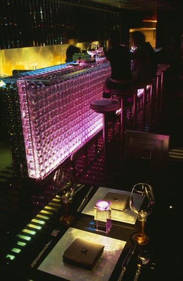 CHINA, Beijing, Tou Ming Si Kao ( TMSK ) bar interior with couple sitting at glass bar illuminated with coloured light.