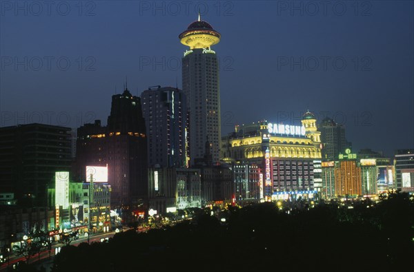 CHINA, Shanghai, "Renmin Square or the People’s Square at night, with buildings illuminated with coloured lights and neon advertising. "