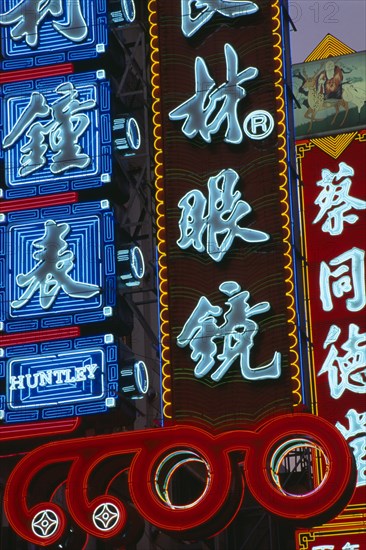 CHINA, Shanghai, Nanjing Lu.  Illuminated neon shop signs in Chinese script.