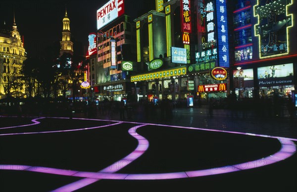 CHINA, Shanghai, "Nanjing Lu.  Street scene at night with illuminated coloured pavement trail, neon shop signs including McDonalds and crowds in blur of movement. "