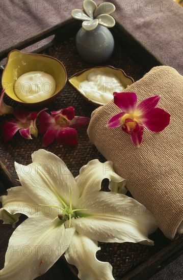 CHINA, Beijing, "Bodhi Therapeutic Retreat.  Tray with creams and lotions, folded towel and lilly and orchid blossom."