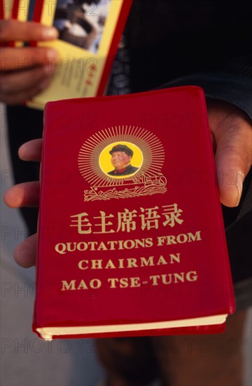 CHINA, Beijing, "Tiananmen Square.  Person holding copy of Mao Tse-Tung’s ‘Little Red Book’ of quotations, required reading of all Chinese citizens during Mao’s rule. "
