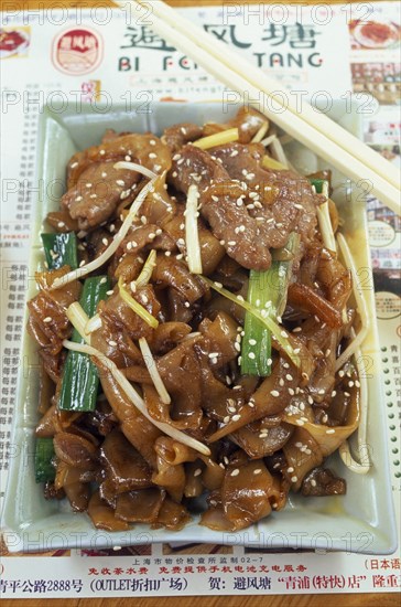 CHINA, Shanghai, Rectangular dish of seseme pork with pair of chopsticks lying across top corner.