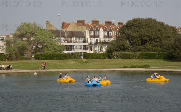 ENGLAND, West Sussex, Littlehampton, Families enjoying pedal boat rides at Oyster Pond Boating Lake