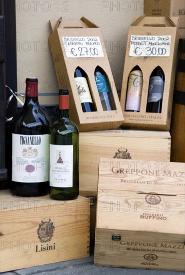ITALY, Tuscany, Montalcino, Wine shop in the medieval hilltown with a display of wine bottles and boxes of different sizes with prices displayed in Euros
