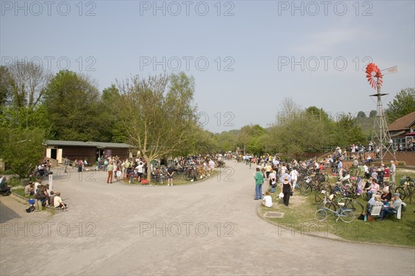 ENGLAND, West Sussex, Amberley, Amberley Working Museum. Veteran Cycle Day Grand Parade with visitors watching people riding bicycles displaying the development  and history of cycle design