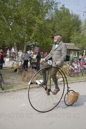 ENGLAND, West Sussex, Amberley, Amberley Working Museum. Veteran Cycle Day Grand Parade. Young boy riding a Penny Farthing bicycle