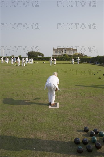 ENGLAND, West Sussex, Bognor Regis, Men and women playing a game of bowls on beach front green