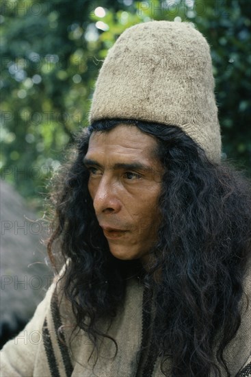 COLOMBIA, Sierra Nevada de Santa Marta, Ika, Portrait of Ika man wearing traditional woven wool and cotton cloak and finely woven fique cactus helmet. Arhuaco Aruaco indigenous tribe American Classic Classical Colombian Columbia Hispanic Historical Indegent Latin America Latino Male Men Guy Older South America