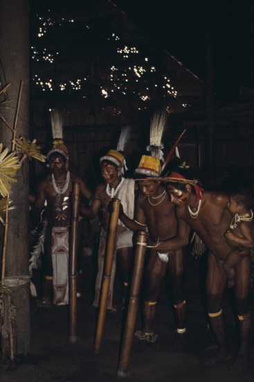 COLOMBIA, North West Amazon, Tukano Indigenous People, Barasana stave dance.  Line of male dancers wearing body paint and feather head-dresses. Tucano sedentary Indian tribe Western Amazonia American Colombian Columbia Hispanic Kids Latin America Latino Performance South America Tukano Turkano