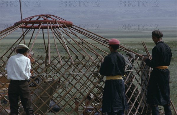 MONGOLIA, Gobi Desert, Khalkha herdsmen erecting the family ger or yurt on pastureland of Bigersum  Freedom negdel collective.First the frame must be set in the ground.  . Khalha East Asia Asian Mongol Uls Mongolian