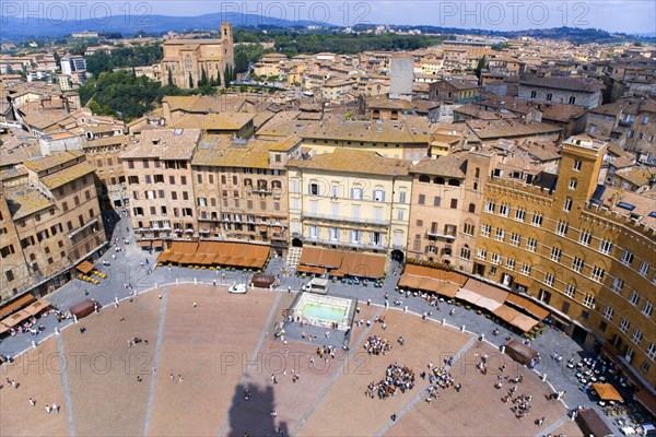 ITALY, Tuscany, Siena, View over the Piazza del Campo and the north of the city. People walk in the square past the Palazzi and restaurants that border it