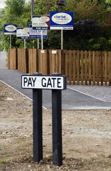 ENGLAND, West Sussex, Washington, To Let and For Sale signs on wooden fencing outside a newly built housing development in a road called Pay Gate