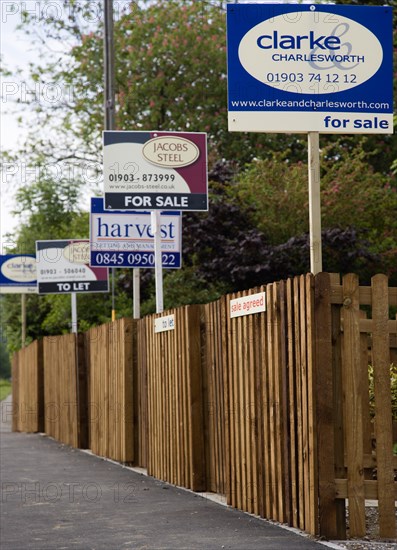 ENGLAND, West Sussex, Washington, To Let and For Sale signs on wooden fencing outside a newly built housing development