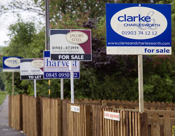 ENGLAND, West Sussex, Washington, To Let and For Sale signs on wooden fencing outside a newly built housing development