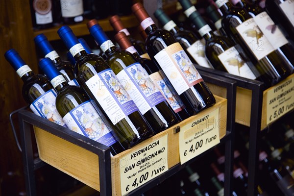 ITALY, Tuscany, San Gimignano, Bottles of Chianti and Vernaccia di San Gimignano wines displayed for sale outside a shop with prices given in Euros