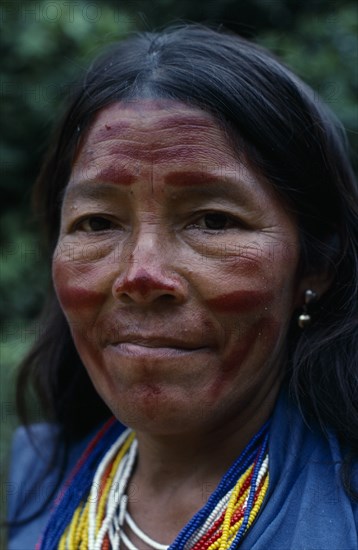 COLOMBIA, North West Amazon, Tukano Indigenous People, Head and shoulders portrait of Makuna widow with traces of dark red Achiote facial paint and multiple strands of red  blue  yellow and white beads indicating wealth Tukano  Makuna Indian North Western Amazonia American Colombian Columbia Hispanic Indegent Latin America Latino South America Tukano
