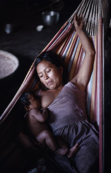 COLOMBIA, North West Amazon, Tukano Indigenous People, Makuna mother  Venancio's wife  breastfeeding baby lying in hammock. Tukano  Makuna Indian North Western Amazonia family American Babies Colombian Columbia Hispanic Indegent Kids Latin America Latino Mum South America Tukano