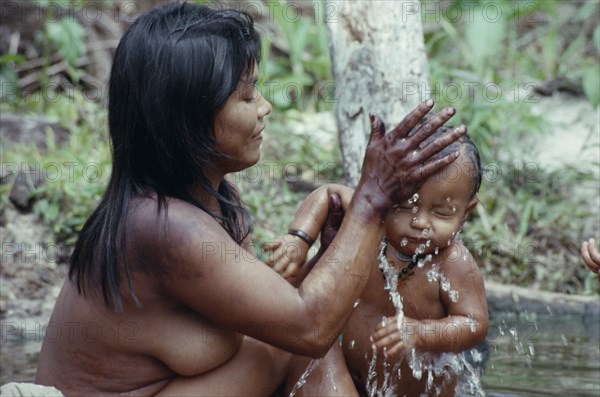 COLOMBIA, North West Amazon, Tukano Indigenous People, Young Makuna mother washing her baby at the river port. Tukano  Makuna Indian North Western Amazonia family cleaning bathing American Babies Colombian Columbia Hispanic Indegent Kids Latin America Latino Mum South America Tukano