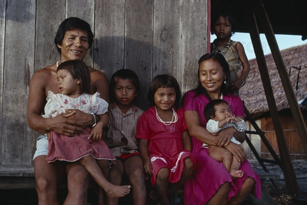 COLOMBIA, North West Amazon, Tukano Indigenous People, Makuna family - Venancio one of headman Bosco' sons  with his wife and five children outside their recently constructed small family home. Venancio is the teacher in the local Makuna school   Makuna Indian North Western Amazonia  cassava American Colombian Columbia Hispanic Indegent Latin America Latino Male Men Guy South
