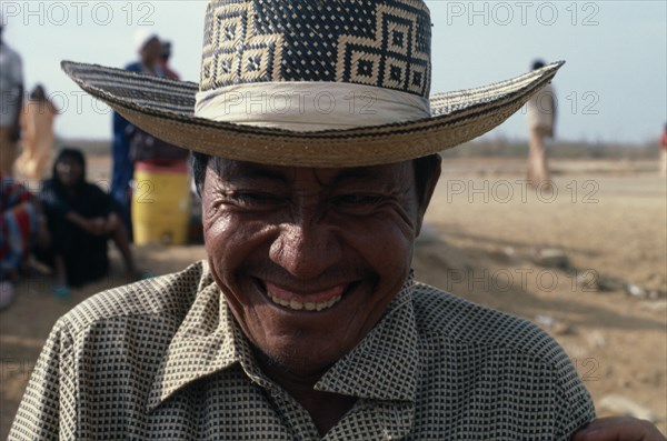 COLOMBIA, Guajira Peninsula, Guajiro Indians, Head and shoulders portrait of laughing Guajiro cacique leader & contraband dealer in desert peninsula  with typical woven Magdalena valley cowboy hat and set of false teeth. Wayu Wayuu  Amerindian Arawakan Colombia-Venezuela border American Colombian Columbia Hispanic Latin America Latino Male Men Guy South America