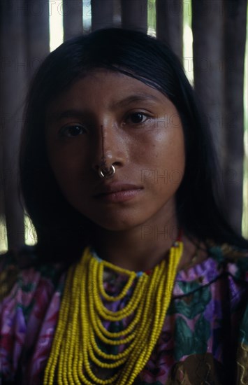 COLOMBIA, Darien, Kuna Indians, Head and shoulders portrait of Kuna girl from the Arquia community wearing gold nose ring  multi stranded necklace of yellow beads and traditional facial decoration consisiting of black stripe running the length of the nose.  Cuna American Classic Classical Colombian Columbia Hispanic Historical Latin America Latino Older South America