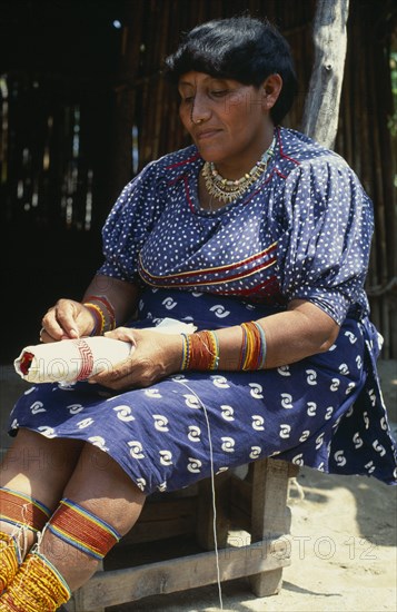 PANAMA, San Blas Islands, Kuna Indians, Older Kuna Indian woman preparing traditional bead design.  Note colourful beads worn around ankles  calves  wrists and forearms Cuna Caribbean American Central America Colorful Female Women Girl Lady Hispanic Latin America Latino Panamanian West Indies