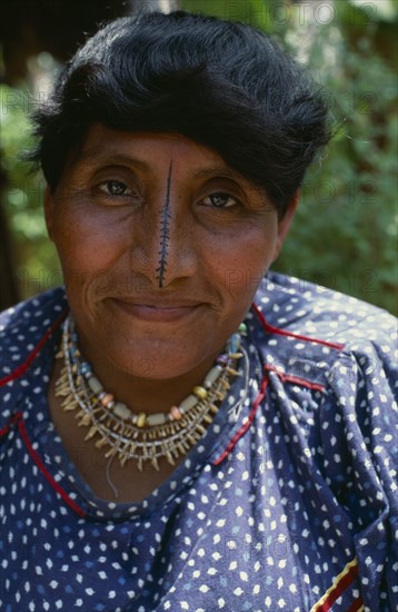 PANAMA, San Blas Islands, Kuna Indians, Portrait of  wife of Kuna headman traditional black stripe drawn down length of nose thought to enhance beauty  bead and monkey teeth necklace  banded bead designs on arms Cuna Caribbean American Central America Female Women Girl Lady Hispanic Latin America Latino Panamanian West Indies