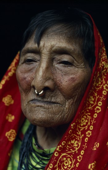 PANAMA, San Blas Islands, Kuna Indians, Head and shoulders portrait of elderly Kuna woman wearing long head scarf and traditional gold nose ring. Cuna Caribbean American Central America Classic Classical Female Women Girl Lady Hispanic Historical Latin America Latino Old Senior Aged Older Panamanian West Indies