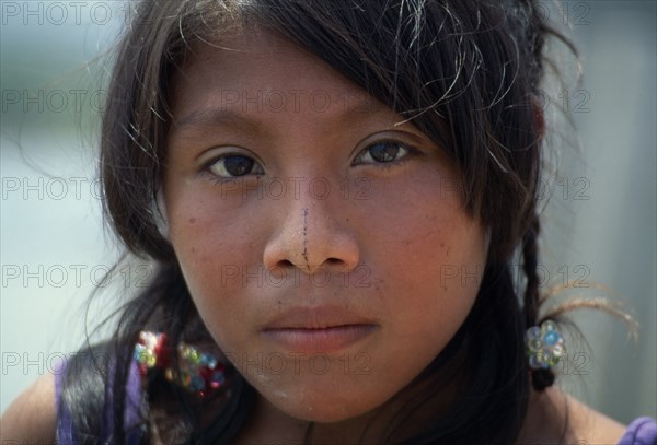PANAMA, San Blas Islands, Kuna Indians, Head and shoulders portrait of young Kuna girl with remnant of traditional black line drawn along length of nose. Cuna Caribbean American Central America Hispanic Latin America Latino Panamanian West Indies