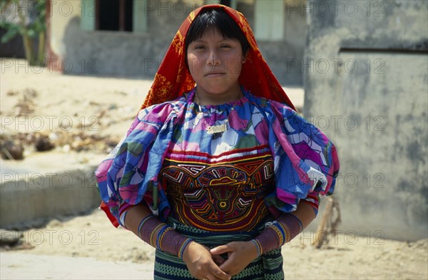 PANAMA, San Blas Islands Tikantiki , Kuna Indians, Kuna girl wearing traditional layered applique mola   gold nose ring with black line drawn along length of nose ring   bead design wrist and arm bands. Cuna Caribbean American Central America Classic Classical Female Women Girl Lady Hispanic Historical Latin America Latino Older Panamanian West Indies