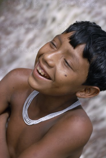 COLOMBIA, North West Amazon, Tukano Indigenous People, Head and shoulders portrait of laughing Barasana boy wearing multi-strand white glass bead necklace. Tukano sedentary Indian tribe North Western Amazonia American Colombian Columbia Hispanic Indegent Kids Latin America Latino South America Tukano