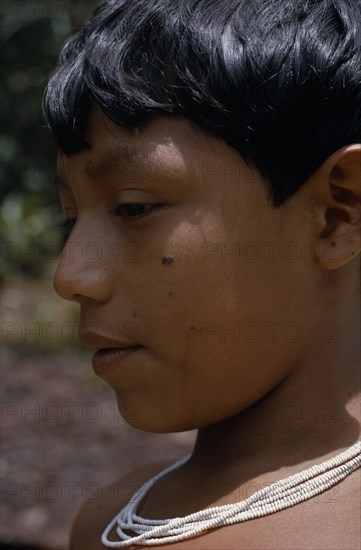 COLOMBIA, North West Amazon, Tukano Indigenous People, Head and shoulders portrait of Barasana boy  profile to left  wearing multi-strand white glass bead necklace.Tukano sedentary Indian tribe North Western Amazonia American Colombian Columbia Hispanic Indegent Kids Latin America Latino South America Tukano