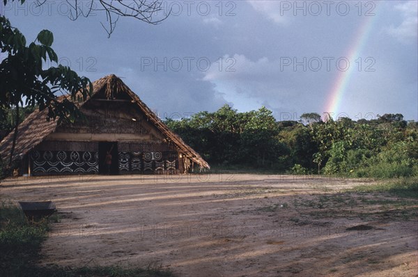 COLOMBIA, North West Amazon, Tukano Indigenous People, Makuna communal tribal or maloca with decorated exterior and cleared dance area in the foreground. Tukano Makuna Indian North Western Amazonia maloca American Colombian Columbia Hispanic Indegent Latin America Latino South America Tukano