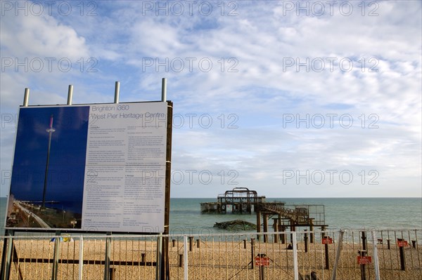 ENGLAND, East Sussex, Brighton, Ruins of the West pier with boards showing plans for the i360 observation tower top be built.