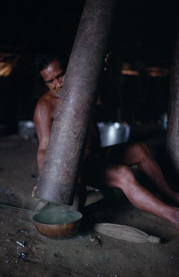 COLOMBIA, North West Amazon, Tukano Indigenous People, Makuna man emptying pounded powdered coca from Yarumo hollow tube into gourd Tukano  Makuna Indian North Western Amazonia American Colombian Columbia  Indegent Latin America Latino Male Men Guy South America Tukano