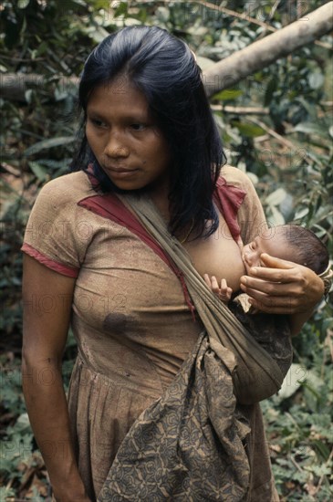 COLOMBIA, North West Amazon, Vaupes, Young Maku mother breast-feeding baby carried in sling across her body. indigenous tribe indian nomadic American Babies Colombian Columbia Hispanic Indegent Kids Latin America Latino Mum South America Vaupes Immature Vaupes