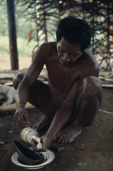 COLOMBIA, North West Amazon, Vaupes, Maku hunter Umero taking salt - a valued commodity  from bottle. indigenous tribe indian nomadic American Colombian Columbia Hispanic Indegent Latin America Latino Male Men Guy South America Vaupes Male Man Guy One individual Solo Lone Solitary Vaupes